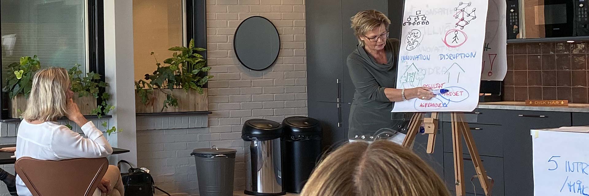 Business coach säljcoach ledarskapscoach Hanna Plymouth vid blädderblock med sittande åhörare på workshop