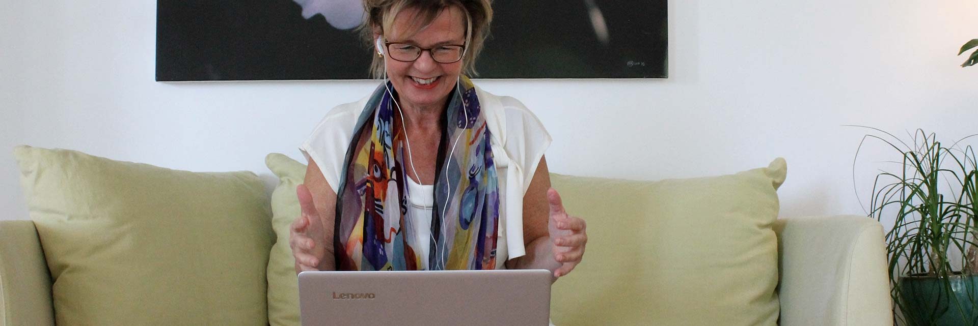 Digital coach på distans, online med dator, säljcoach ledarcoach sittande glad kvinna med fototavla bakom